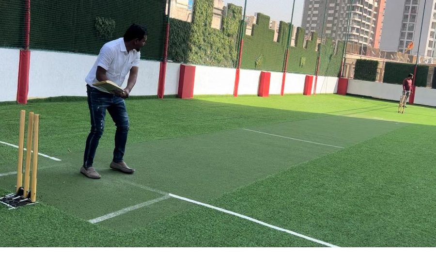 Cricket being played on a laid artificial turf pitch